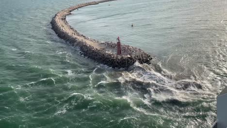 cruise ship leaving the port of la goulette and view of the east jetty lighthouse in tunis and breakwater, tunisia