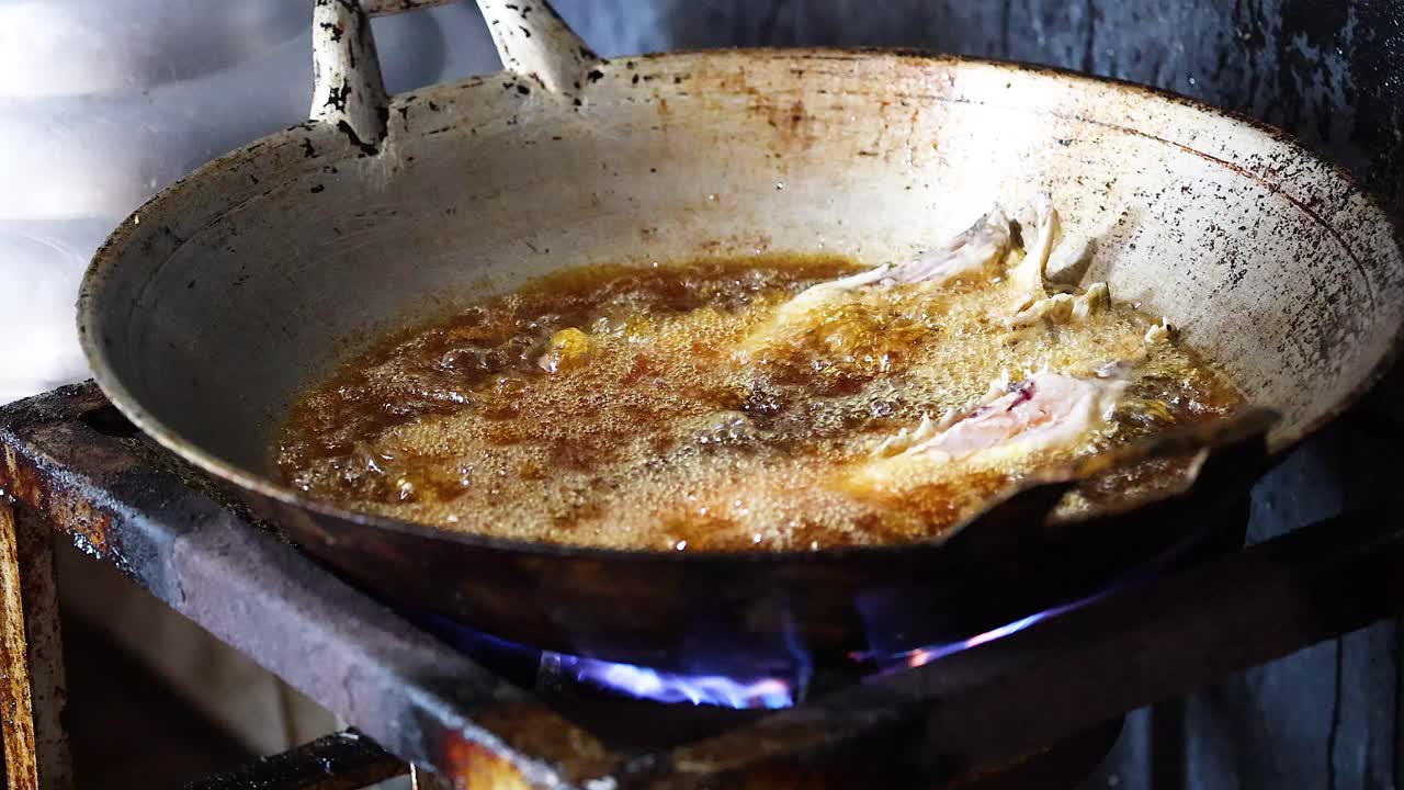Pesce che frigge uniformemente in olio bollente e sfrigolante