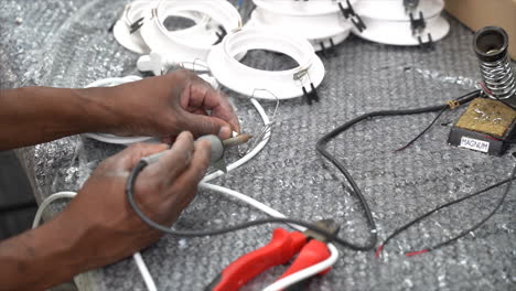 Person-pre-soldering-wires-on-workbench