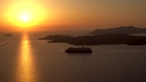 Excellent-view-of-a-cruise-ship-that-passes-by-the-volcano-of-Santorini-at-sunset