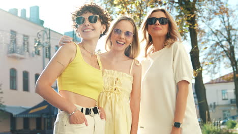 three happy friends enjoying a sunny day in the city