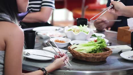 friends sharing food at a korean bbq restaurant