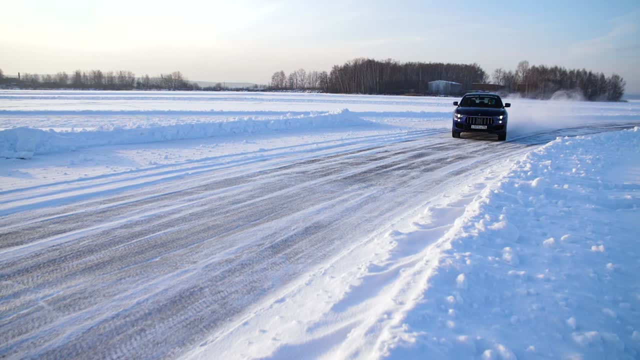 Blue SUV driving on a snowy road in winter
