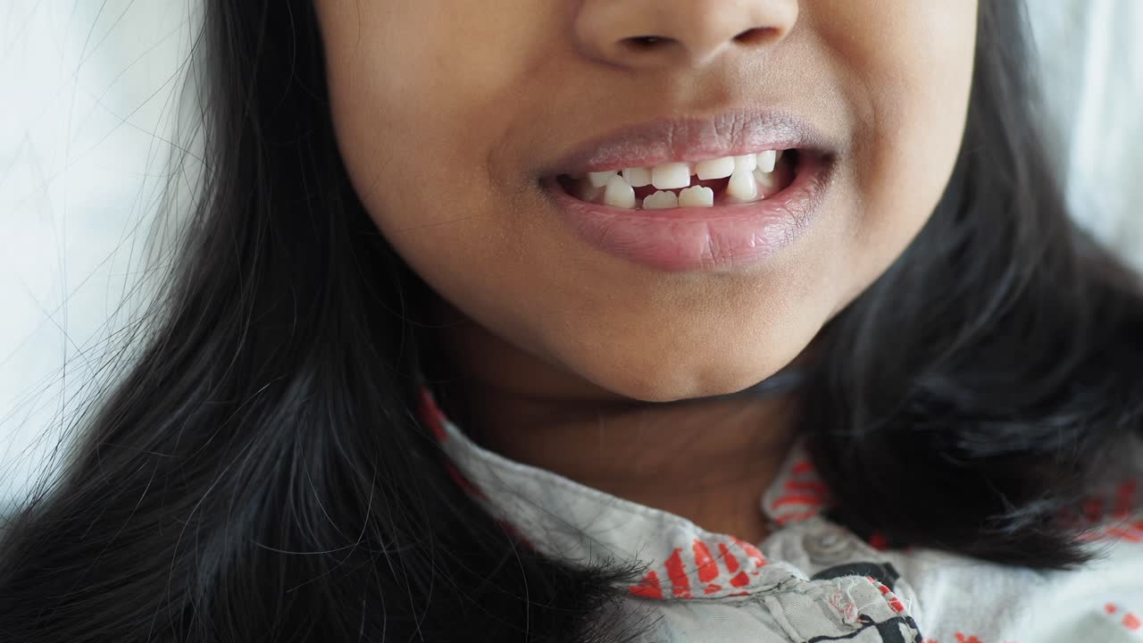 una chica joven sonríe con sus dientes mostrando