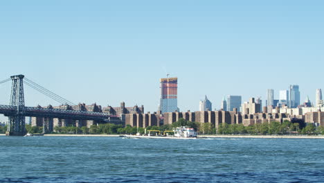 ship on hudson river with skyline and williamsburg bridge