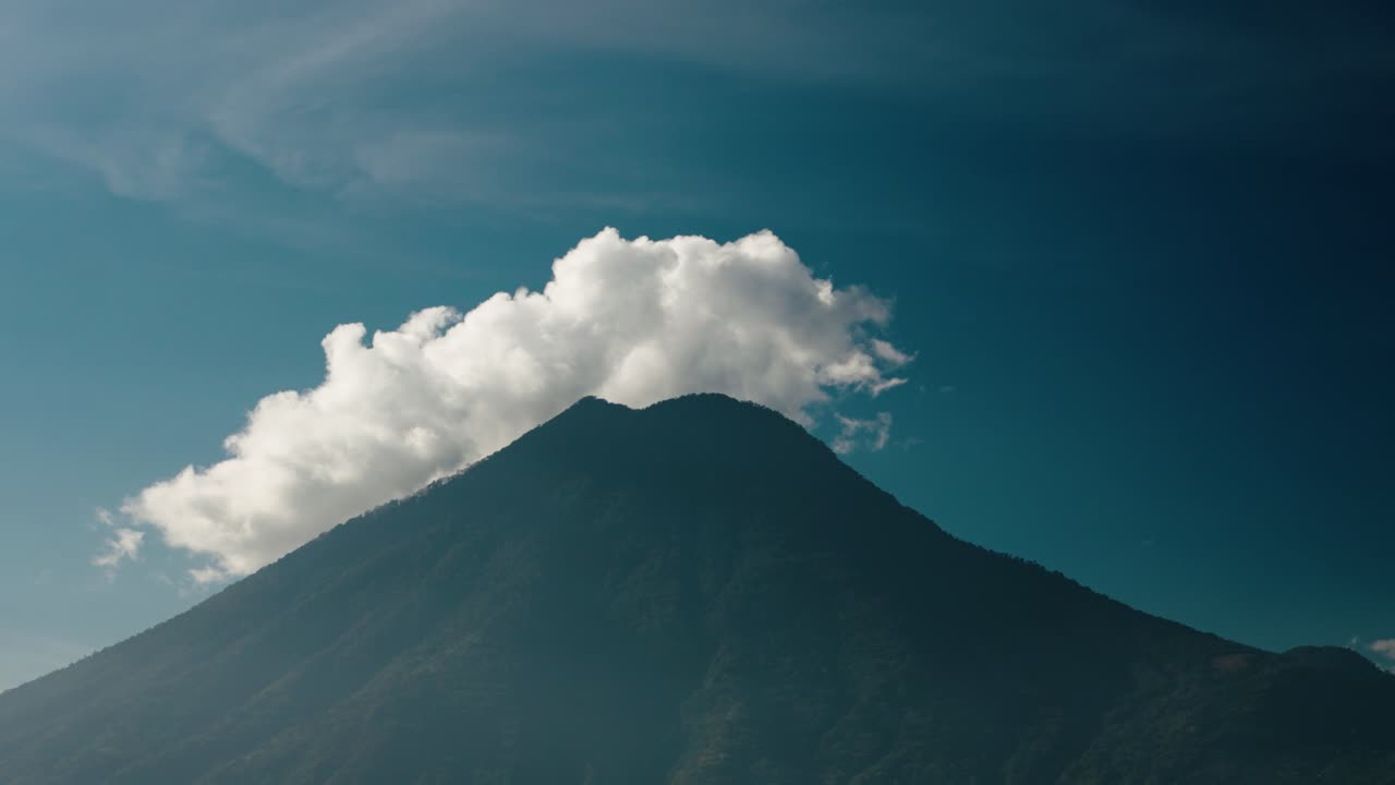Skyerne driver over San Pedro-vulkanen, der rejser sig over Lake Atitlan.