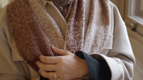 woman in a beige coat and scarf
