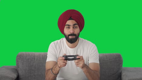 competitive sikh indian man playing video games green screen