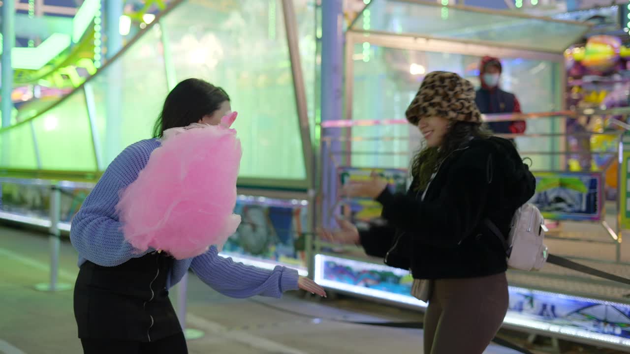 Friends Enjoying Cotton Candy at a Carnival