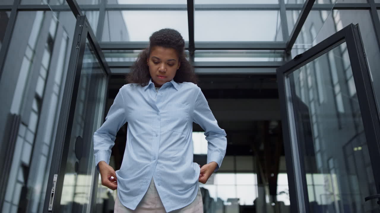 Stressed office worker looking down feeling bored contemporary office building.