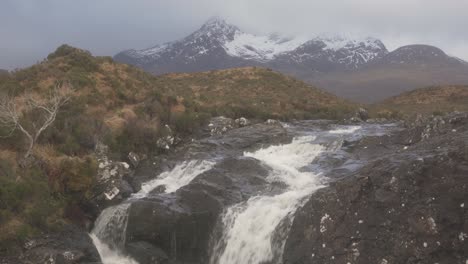 the view of the cuillins and a rushing stream in sligachan on an overcast day