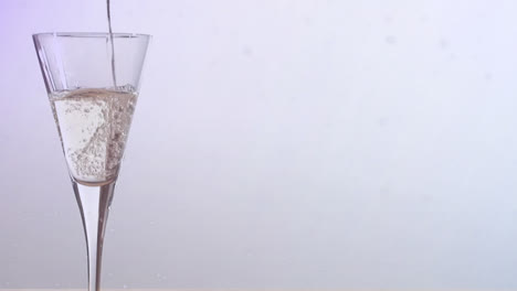 Animation-of-snow-falling-over-champagne-glass-on-white-background