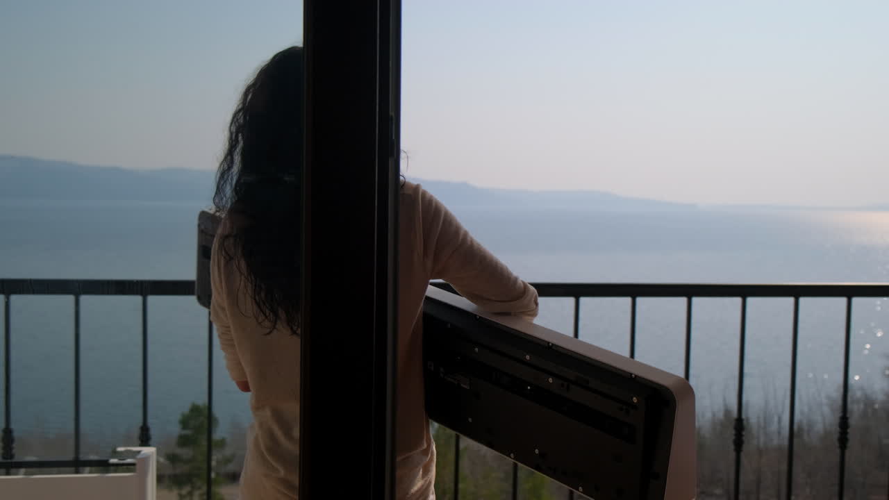 Donna sul balcone che contempla il panorama