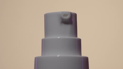 dosing canister of cosmetic cream spinning on cream background