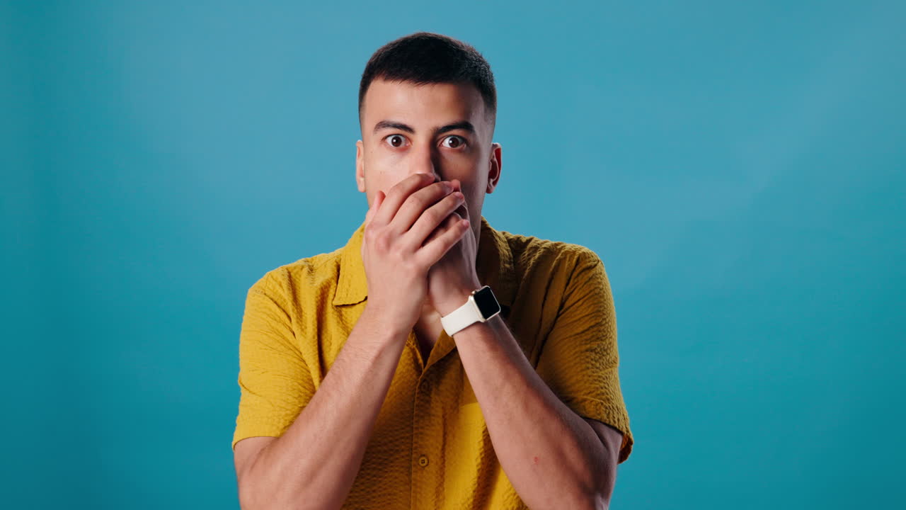 Surprised man covering his mouth