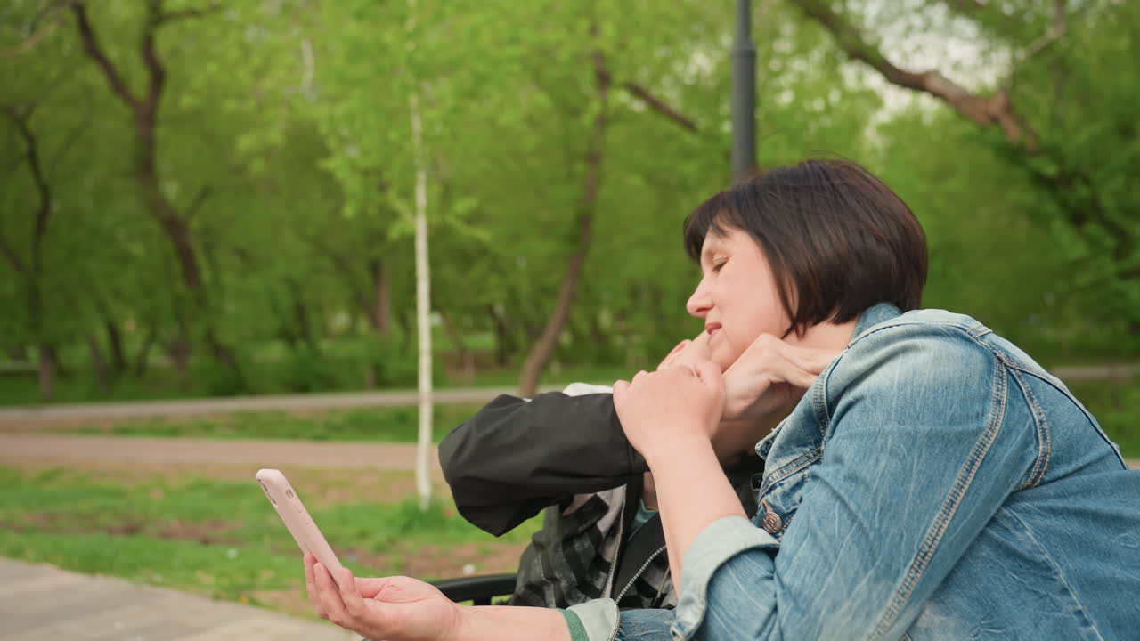 Interactive Park Scene Featuring Caregiving, Playful Interaction Between Mother And Son In Park Setting, Caregiver Engaging With Disabled Child Outdoors Using Visual Aids And Hand Signals