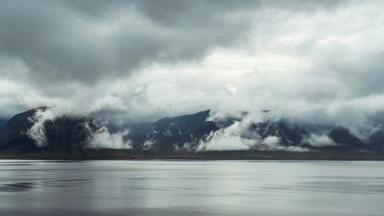 Majestic Mountain By The Lake Surrounded By Dramatic Clouds In Iceland On A Moody Weather - timelapse