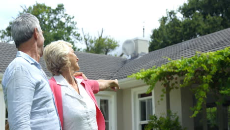 una pareja madura mostrando una casa.
