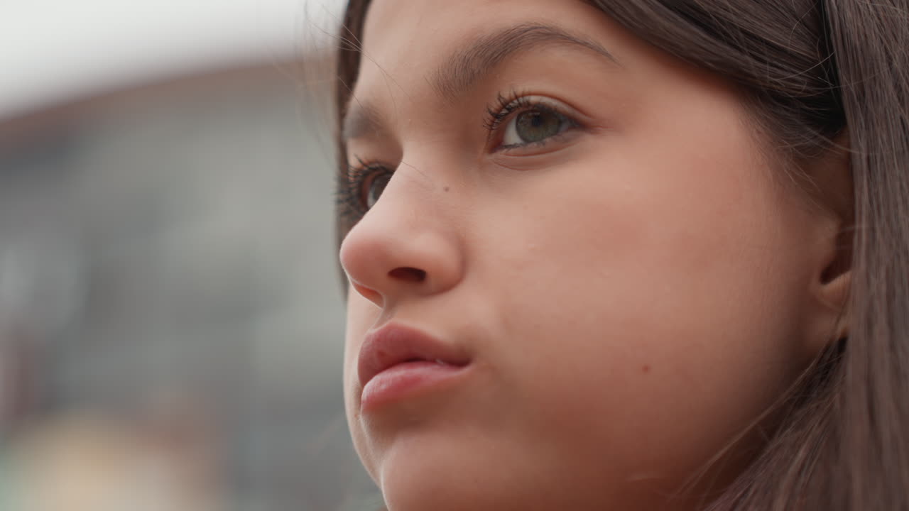 primer plano de un estudiante probando un pastel en una azotea, tomas de perfil con horizonte lejano, viento fresco despeinando el cabello, masticación lenta, glaseado colgando del bocado, mirada solemne a la distancia, ambiente de descanso en el campus