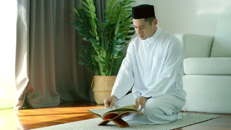 portrait of asian muslim man reciting surah al-fatiha passage of the qur'an, in a daily prayer at home in a single act of sujud called a sajdah or prostration