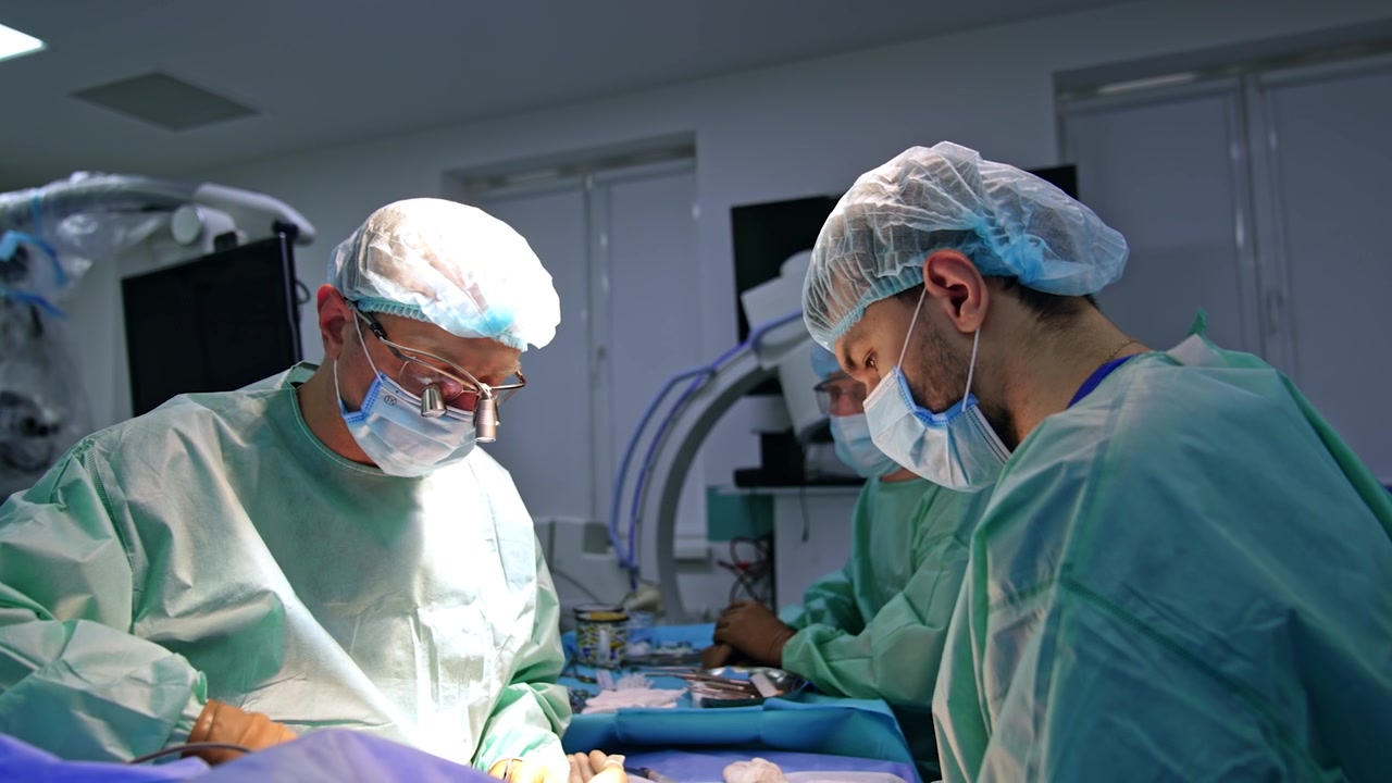 Neurokirurg og assisterende læge opererer en patient. Mandligt team udfører neurokirurgi på et moderne hospital