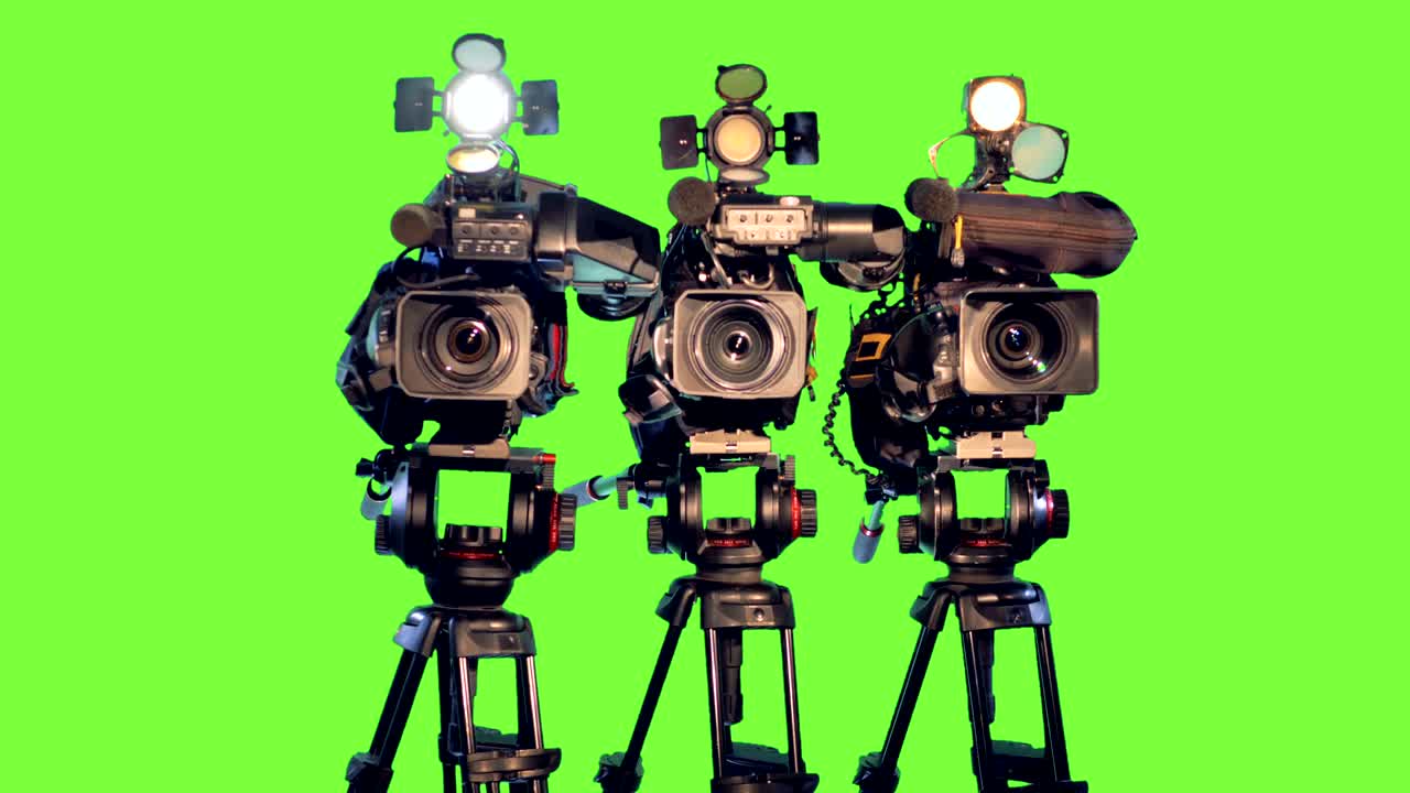 três câmaras de vídeo profissionais, camcorders em trípodes.