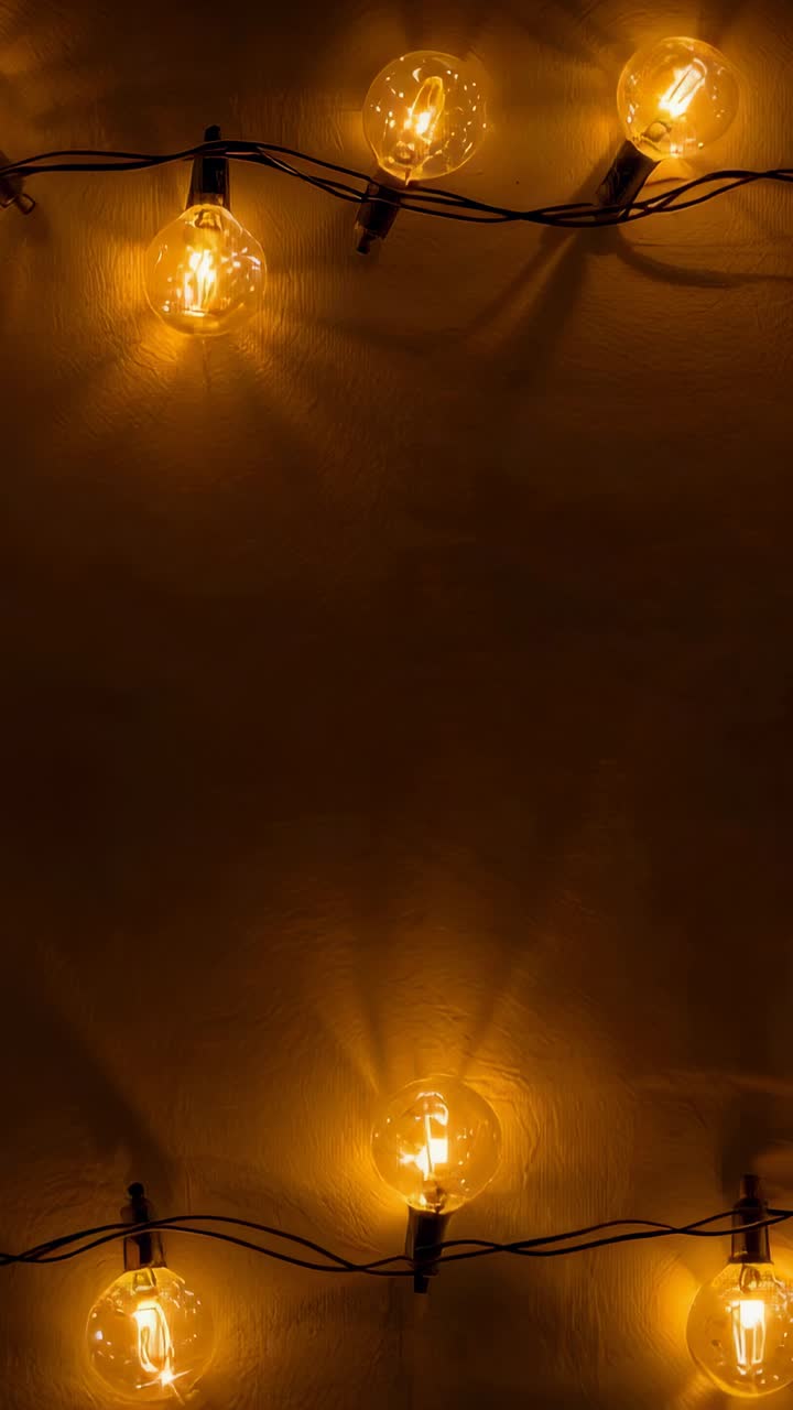 Vertical video: Opening shot showing globe lights pulsing on room wall with black wiring, cozy glow
