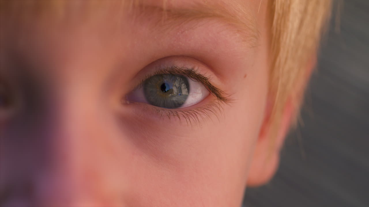 슬로우 모션 매크로는 어린 소년의 아름다운 파란 눈을 닫습니다