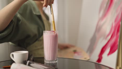 artista pintando y disfrutando de un batido