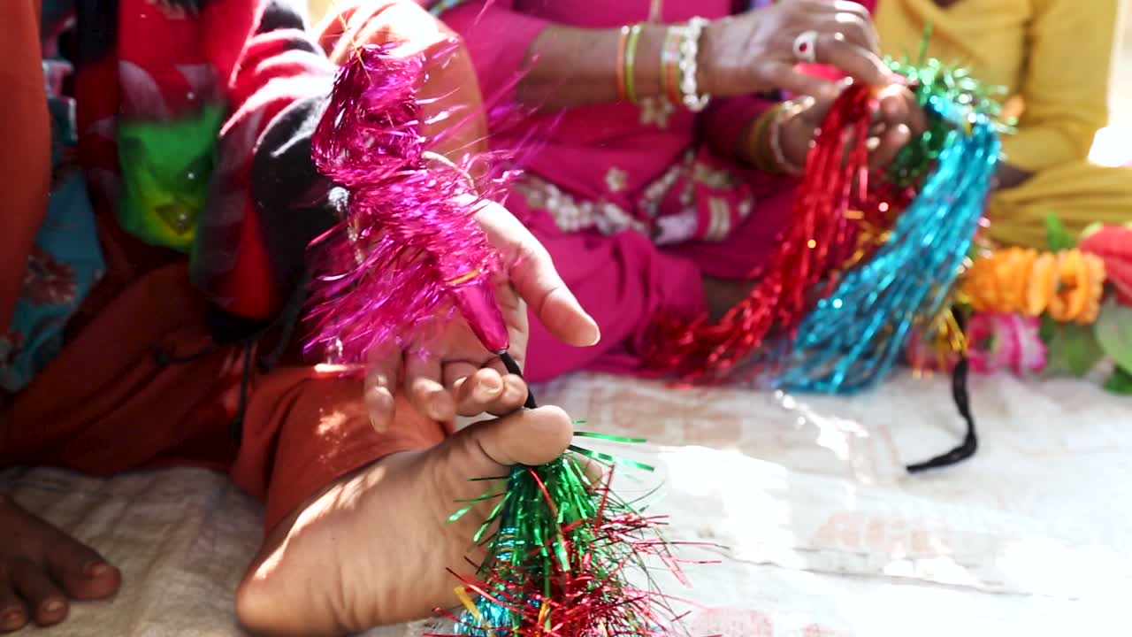 mujeres creando adornos tradicionales con ayuda de manos y pies en la aldea de noondpura, rajasthan