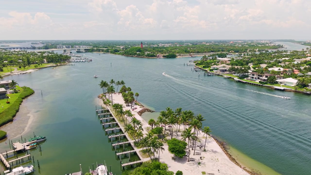 Penisola con marina costeggiata da palme che si estende nell'insenatura di Jupiter, panoramica a media altezza con drone, West Palm Beach Florida USA