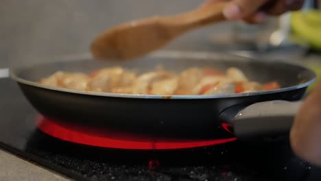 cooking chicken and vegetables in a frying pan