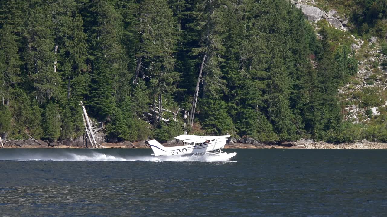해상 비행기 가 산 을 따라 물 에서 이륙 하고 있다