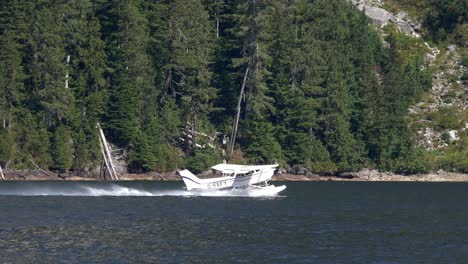 seaplane taking off in the water along the mountain