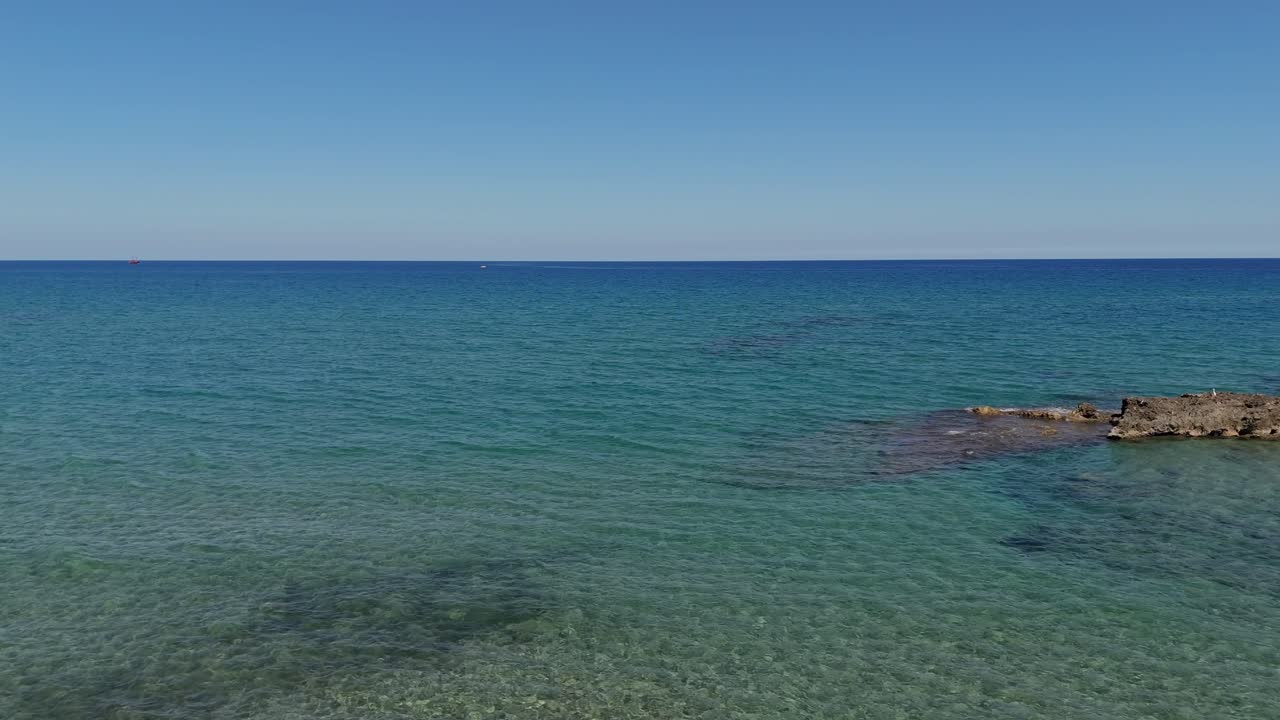 Crystal clear waters and rocky outcrops under a bright sky, showcasing coastal beauty