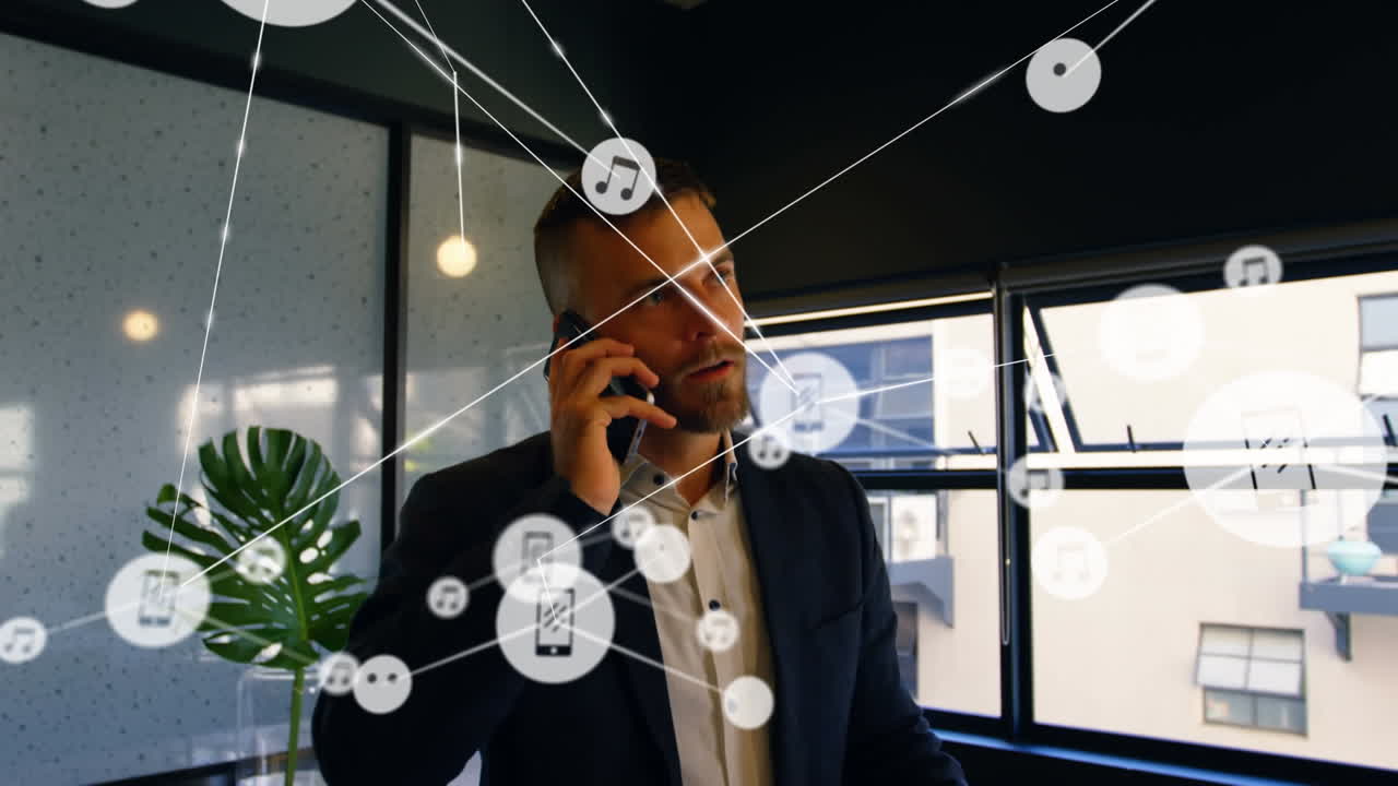Network of digital icons against caucasian businessman talking on smartphone at office