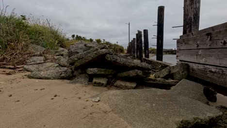 pile of rocks and broken wood barricade in front of the water