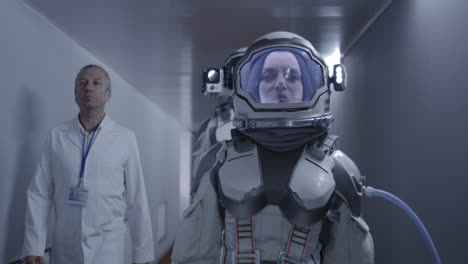 astronaut and scientist in a corridor