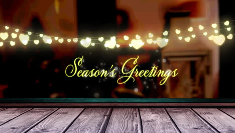 animation of fairy lights and seasons greetings text over wooden boards