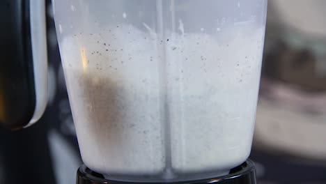 Blender-mixing-milkshake-made-of-chocolate-cookies-and-vanilla-ice-cream-in-slow-motion