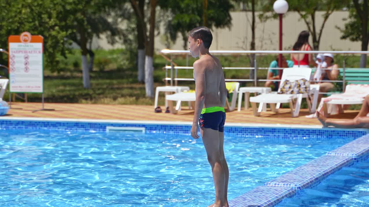 Boy jumping in pool. Happy boy kid jumping in the pool