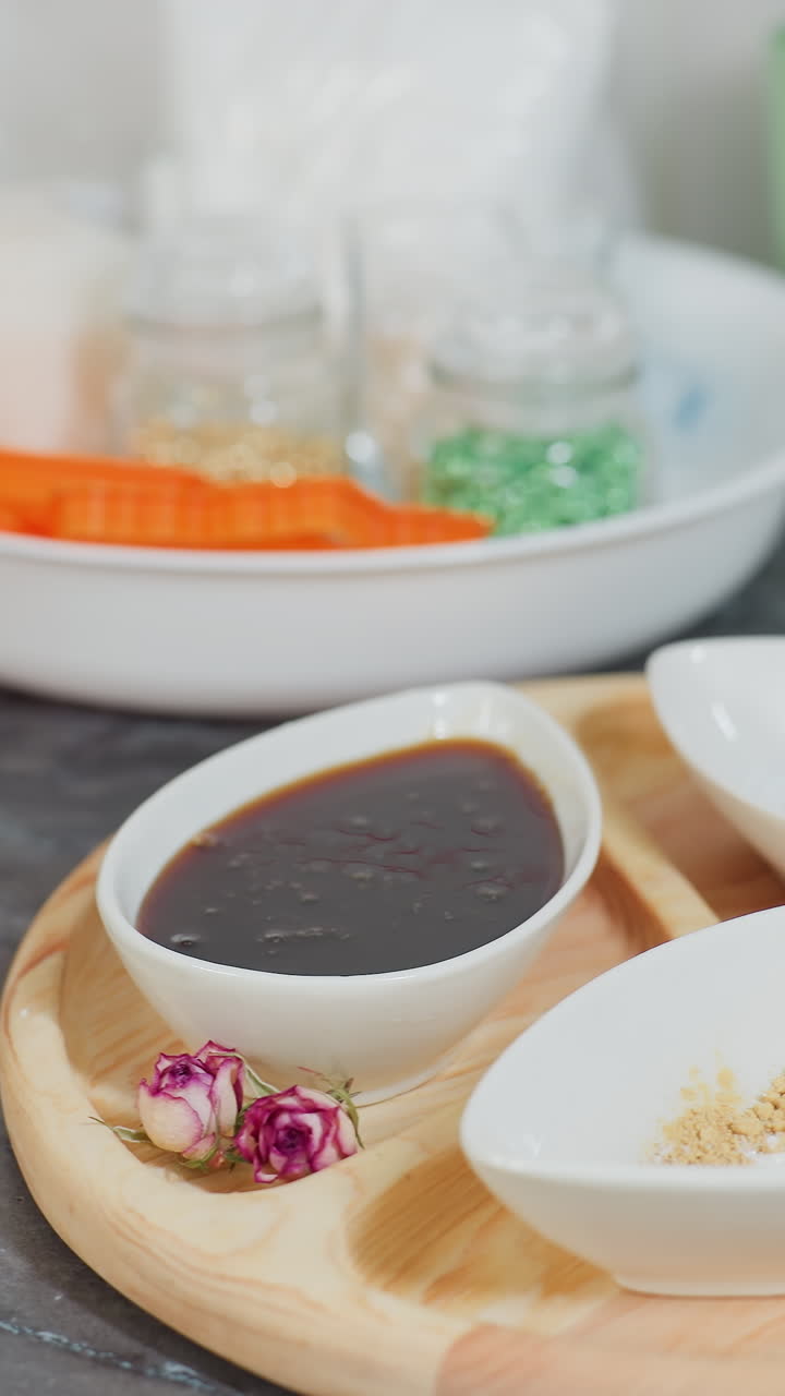 소스와 설탕으로 가득 찬 세라 그, 다채로운 재료가 들어있는 유리 항아리, 접시에 버터, 베이킹 도구 및 유리 비가있는 목조 트레이를 특징으로하는 현대 주방 도구의 클로즈업