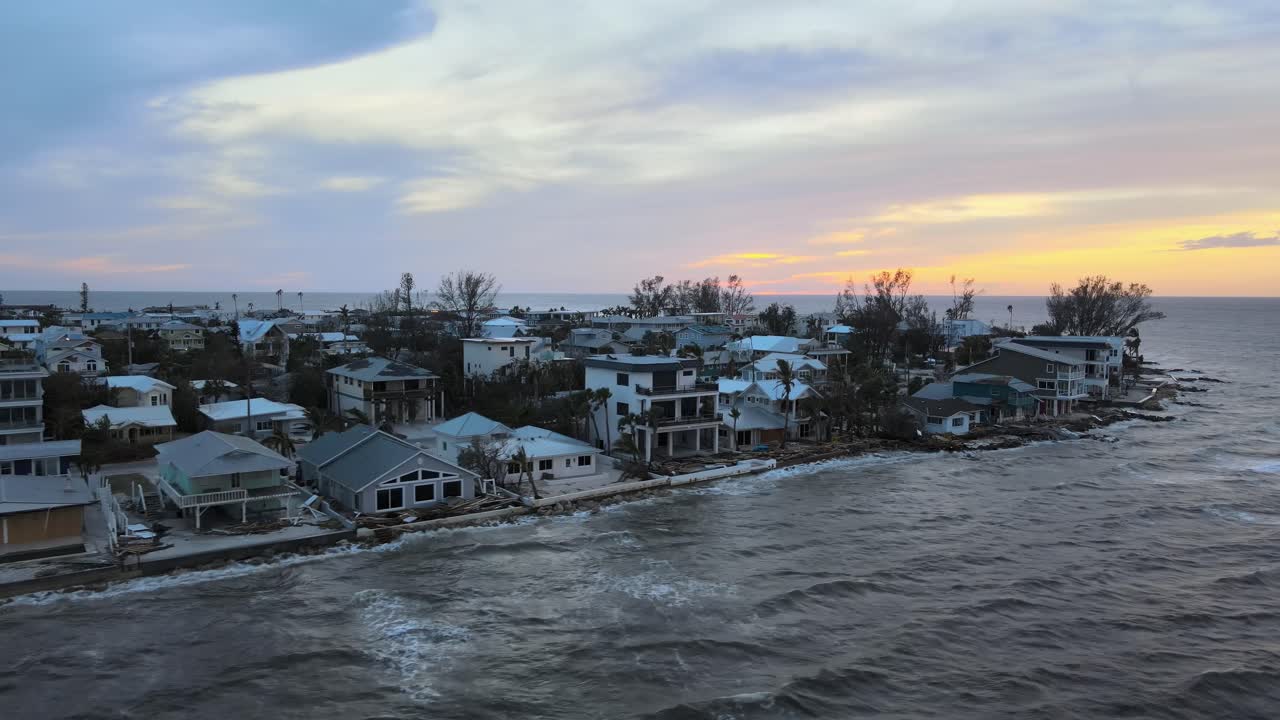 Aerial of Anna Maria Island, Florida at sunset revealing hurricane damage to waterfront homes. Orbit Right Sunset W