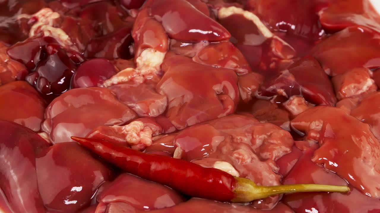 un mucchio di fegato di pollo fresco e crudo con peperoncino, fegato de pollo, carne.