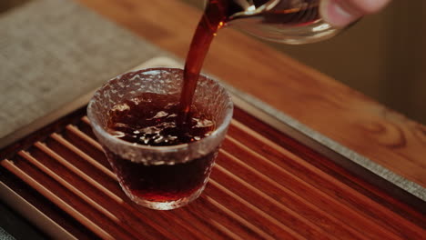 pouring tea into a glass cup