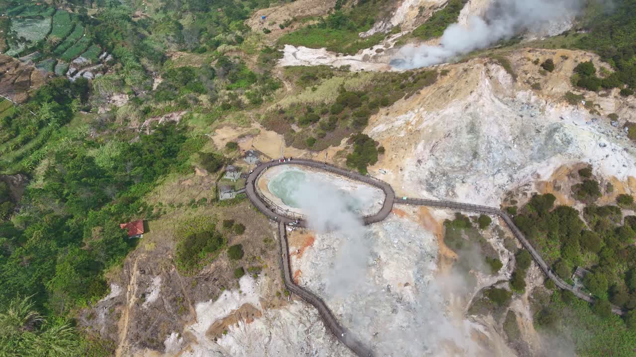 Drone view of Sikidang Crater, Central Java, featuring geothermal activity, sulfuric steam, and surrounding hills in the highlands of Dieng