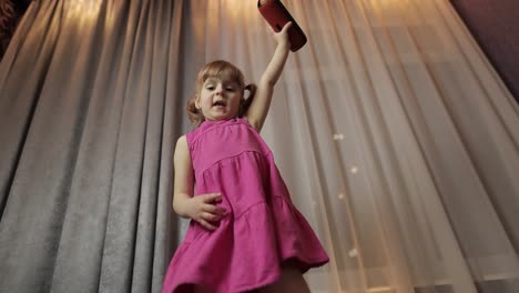niña con altavoz inalámbrico disfrutando de escuchar música. bailando en casa
