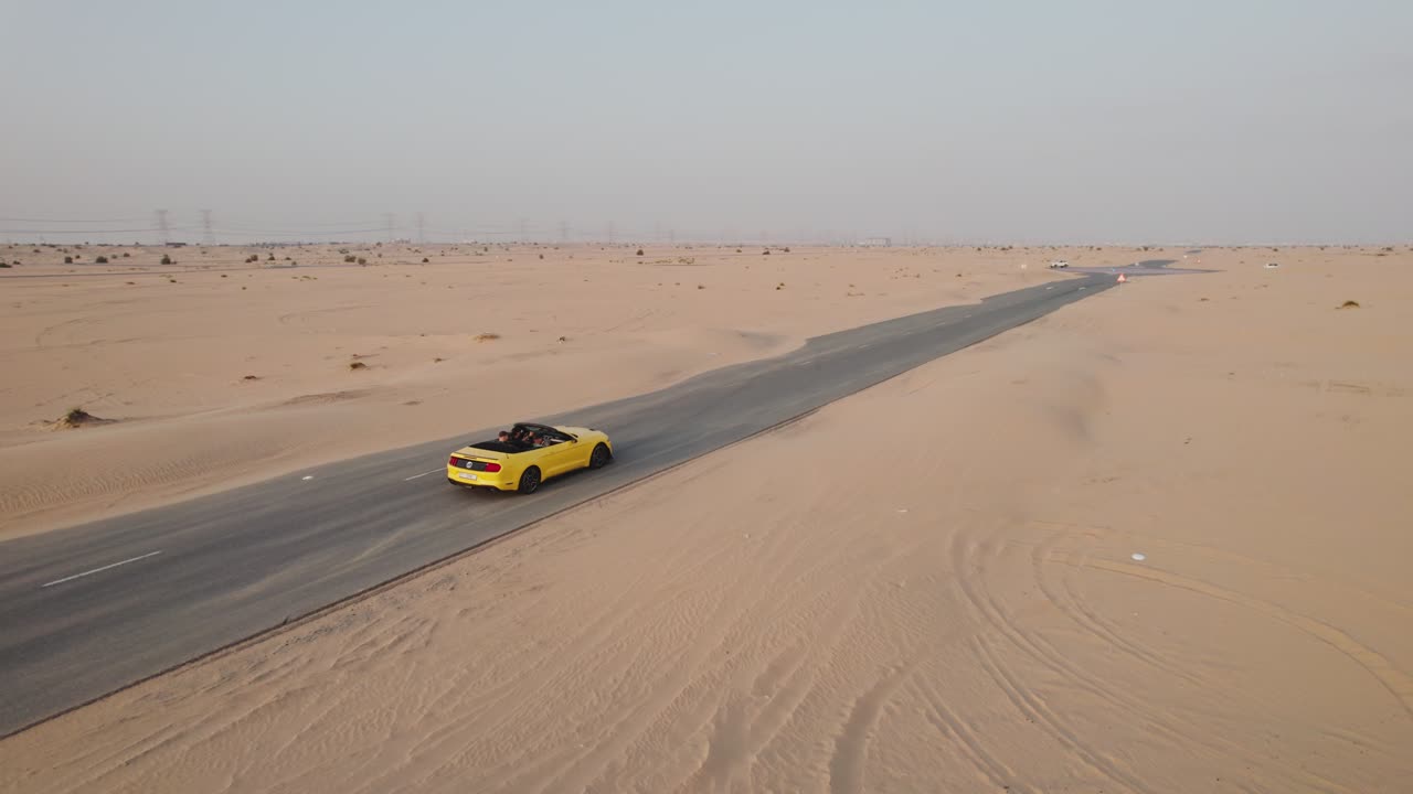 mustang descapotable amarillo conduciendo a través del desierto