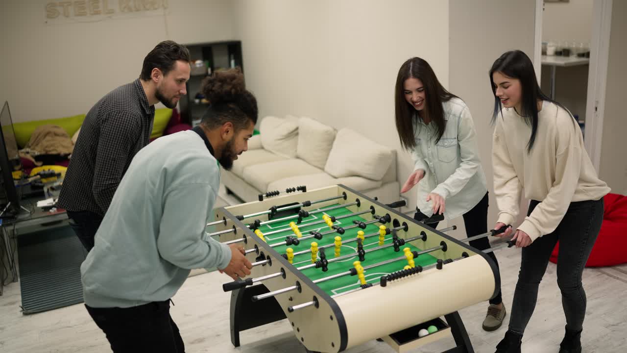 compañeros de trabajo disfrutando de un juego de fútbol en la mesa de futbolín después del trabajo