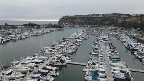 aerial drone view over yachts, at the dana point marina, in dark, cloudy california, usa